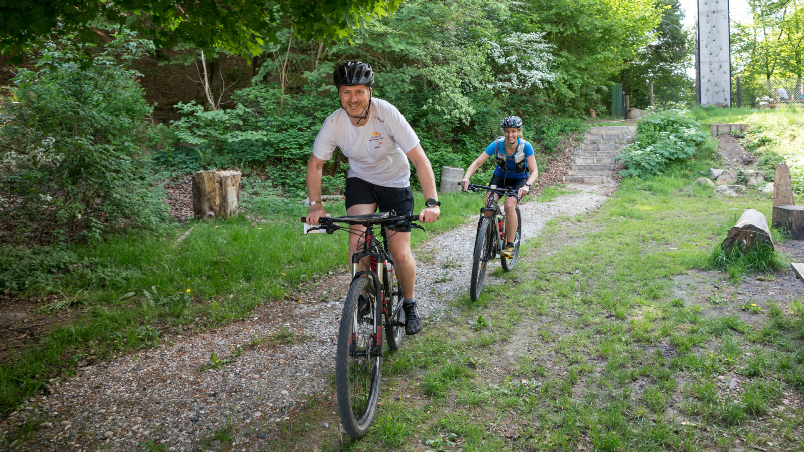 to personer der cykler i skoven